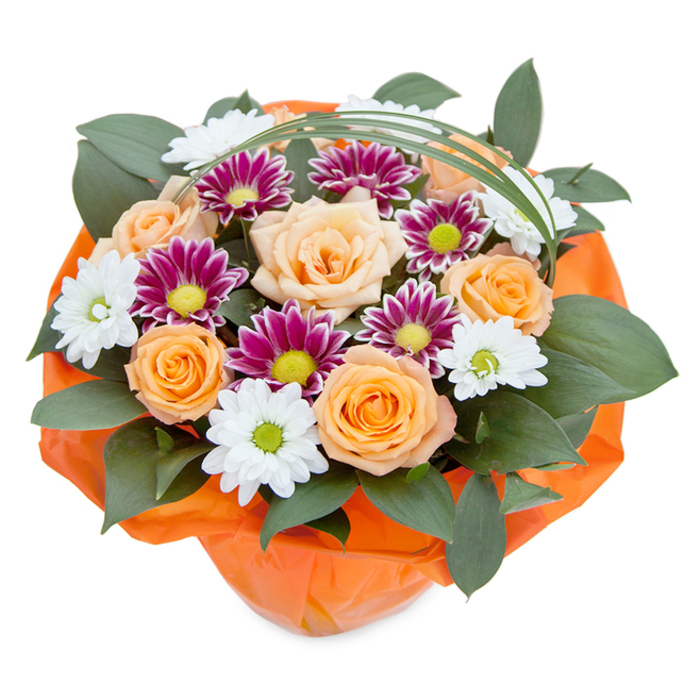 This opulent bouquet, set against a clean, white background and captured from above, feels as fresh and invigorating as a morning stroll through Manor House. At its centre, sumptuous roses bloom in a gradient stretching from pale peach to spirited orange, their petals opening with intentional artistry to reveal soft, velvety folds-an echo of the gentle vibrance seen in local North London gardens mid-spring. Amongst the roses, white chrysanthemum daisies radiate with delicate, pure petals framing tender green centres, offering a vision of effortless tranquility. Touches of lustrous magenta and deep purple chrysanthemums punctuate the design, their fine petals and zingy central discs providing unexpected bursts of colour, reminiscent of the flower stalls that brighten Seven Sisters Road. The bouquet achieves fullness and structure with dark, glossy leaves-possibly ruscus-which weave between blooms to create a foundation as lush as Woodberry Wetlands itself. Slender bear grass forms a graceful arc above, introducing movement and contemporary flair. The base is lovingly bundled in vibrant, crinkled orange cellophane, reflecting the roses' warmth and preparing the design as an elegant gift for delivery throughout Manor House. Each layer, each petal and leaf, embodies the expertise and creativity found within the local floral community, making this bouquet an ideal gesture for those wishing to share beauty and emotion in equal measure.